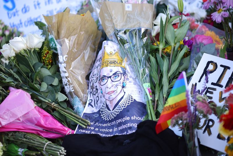 © Reuters. Flowers and tributes are seen as people gather in front of the U.S. Supreme Court following the death of U.S. Supreme Court Justice Ruth Bader Ginsburg, in Washington