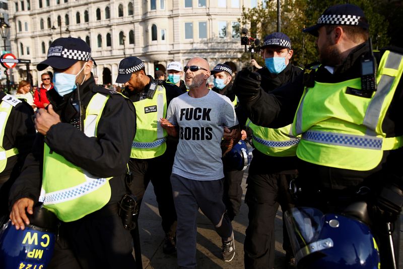 © Reuters. اشتباكات بين الشرطة ومتظاهرين يحتجون على إجراءات العزل في لندن