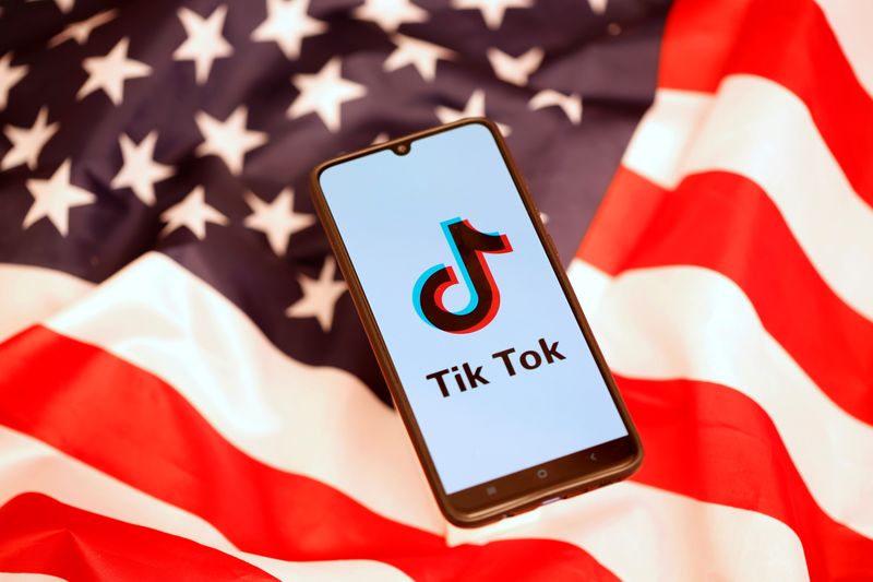 &copy; Reuters. El logotipo de TikTok en la pantalla de un teléfono móvil sobre el fondo de una bandera estadounidense