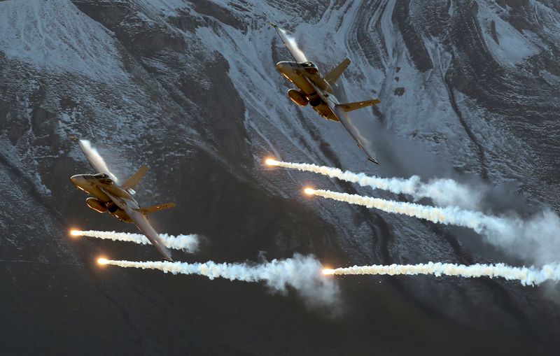 &copy; Reuters. FILE PHOTO: Swiss Air Force F/A18 Hornet fighter jets release flares over the Axalp