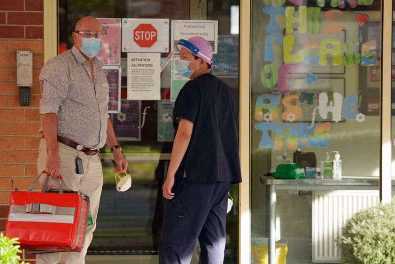 &copy; Reuters. FOTO DE ARCHIVO: Dos trabajadores sanitarios en el exterior del centro Florence Aged Care Facility en Melbourne