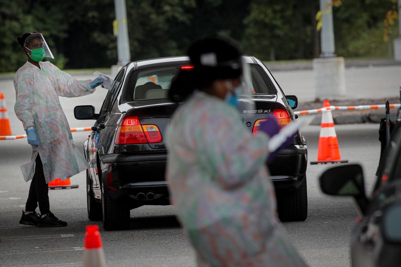 © Reuters. Medical technicians work at a drive-thru coronavirus disease (COVID-19) testing facility at the Regeneron Pharmaceuticals company's Westchester campus in Tarrytown, New York