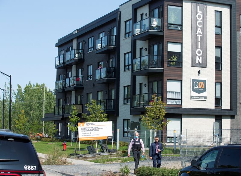 &copy; Reuters. Police investigators walk past a condo building in Longueil