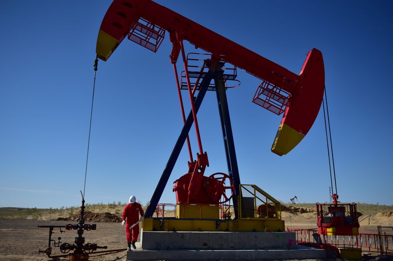 &copy; Reuters. Worker inspects a pump jack at an oil field in Tacheng, Xinjiang