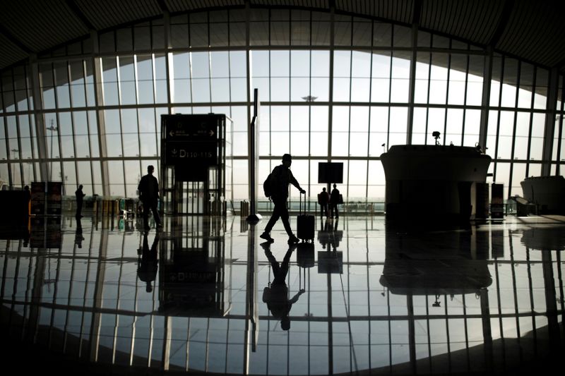 © Reuters. FILE PHOTO: Travellers are seen silhouetted at Beijing Daxing International Airport
