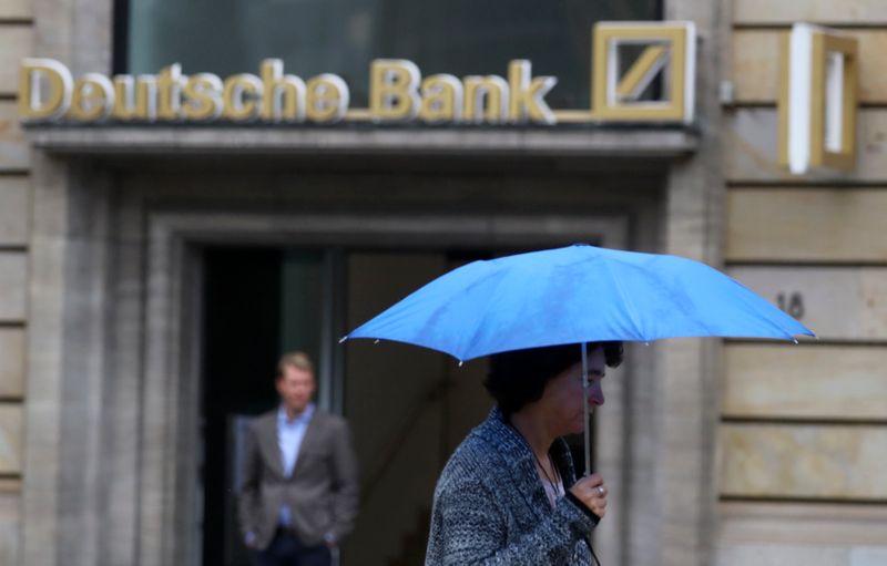 &copy; Reuters. A woman with umbrella walks past a Deutsche Bank branch in Frankfurt