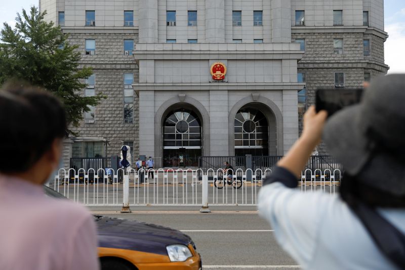 &copy; Reuters. FOTO DE ARCHIVO: Una mujer sostiene un teléfono móvil frente al Tribunal Popular Intermedio Nº 2 de Pekín