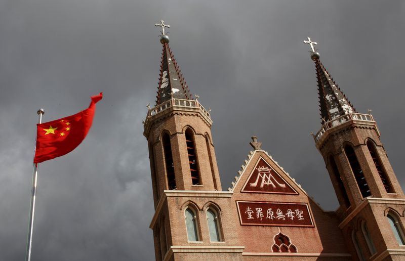 © Reuters. FILE PHOTO: The Chinese national flag flies in front of a Catholic church in the village of Huangtugang