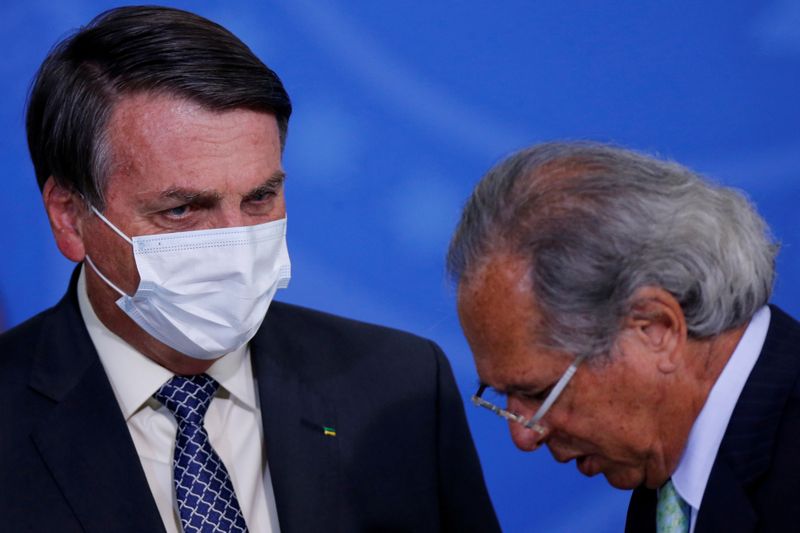 &copy; Reuters. FILE PHOTO: Brazil&apos;s President Jair Bolsonaro talks with Brazil&apos;s Economy Minister Paulo Guedes during a ceremony to launch a program to expand access to credit at the Planalto Palace in Brasilia