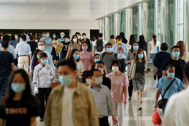 &copy; Reuters. FILE PHOTO: People wearing face masks walk at a shopping mall in Hong Kong