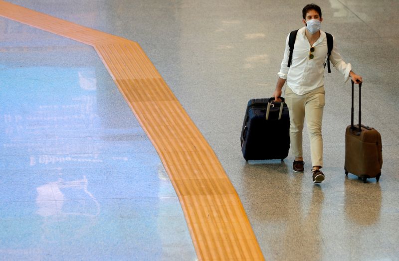 &copy; Reuters. Un uomo indossa la mascherina all&apos;interno dell&apos;aeroporto di Roma Fiumicino