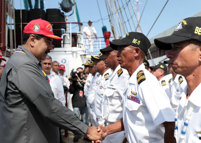 © Reuters. FILE PHOTO: Venezuela's President Nicolas Maduro shakes hands with an officer of the Simon Bolivar training ship, Venezuelan navy's flagship, in La Guaira
