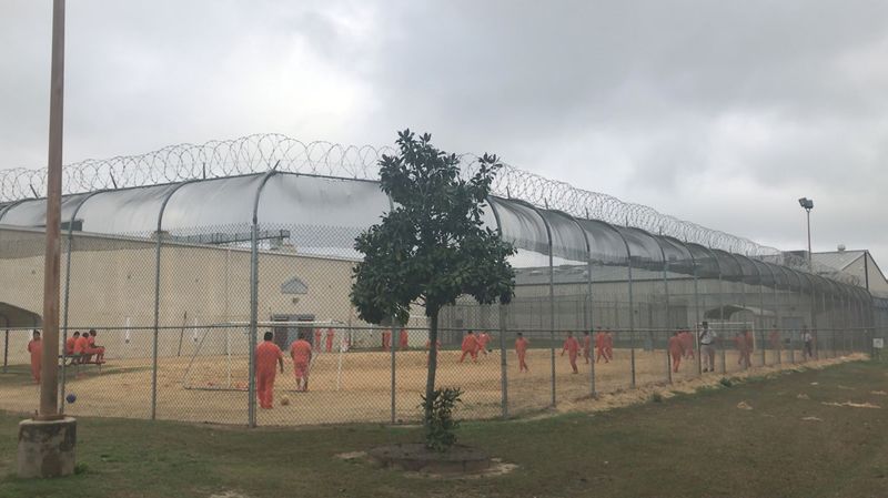 © Reuters. Detained immigrants play soccer behind a barbed wire fence at the Irwin County Detention Center in Ocilla