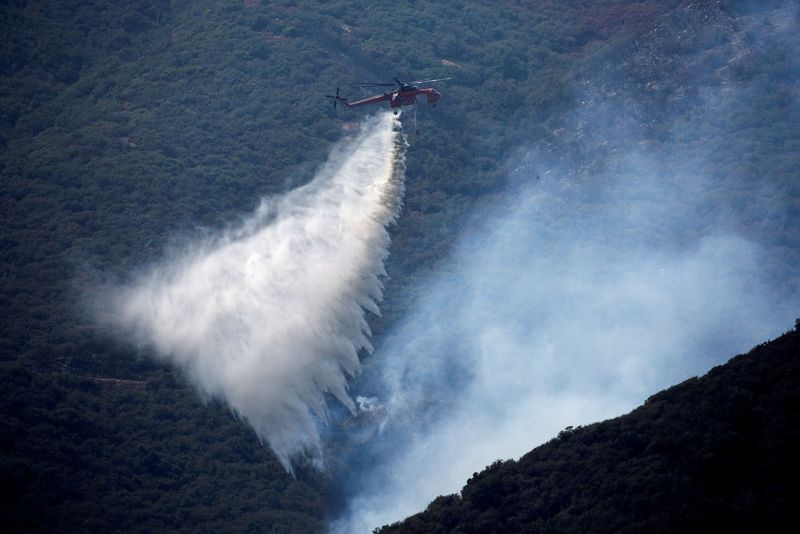 &copy; Reuters. FILE PHOTO: A helicopter makes a water drop over a wildfire in the Angeles National Forest during the Bobcat Fire in Los Angeles