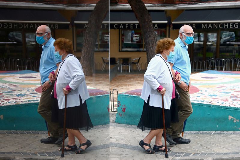 &copy; Reuters. Una pareja de ancianos con mascarillas protectoras se refleja en un vidrio mientras caminan por el barrio de Usera, en Madrid, España, el 23 de septiembre de 2020