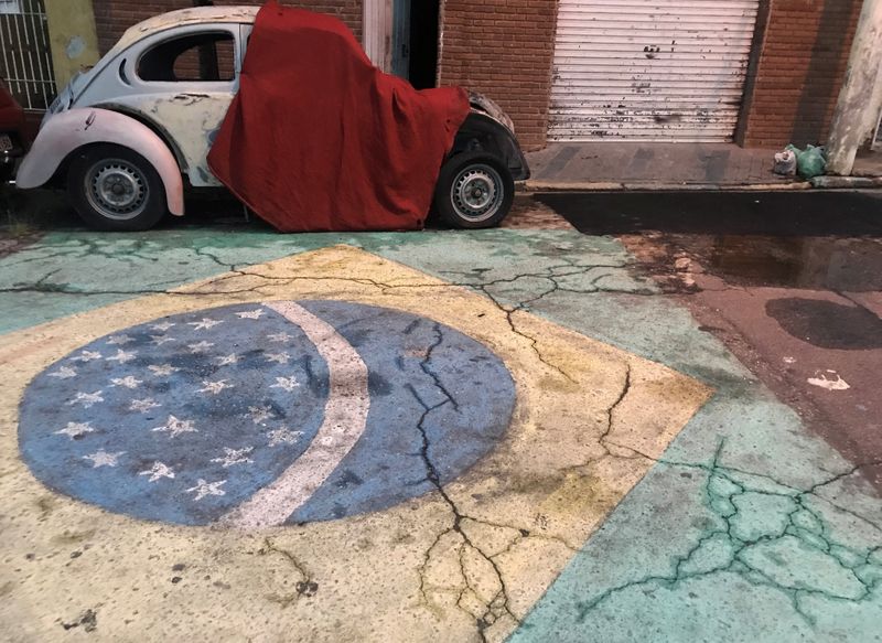&copy; Reuters. A Brazilian flag is seen painted on a street in front of a Volkswagen Beetle car in Sao Paulo