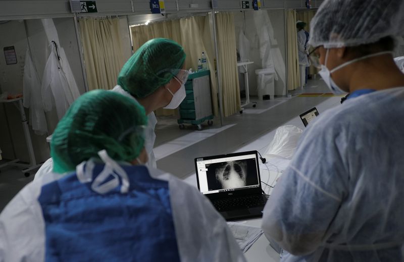 &copy; Reuters. Profissionais da saúde observam exame de paciente de Covid-19 em hospital de campanha no Rio de Janeiro (RJ)