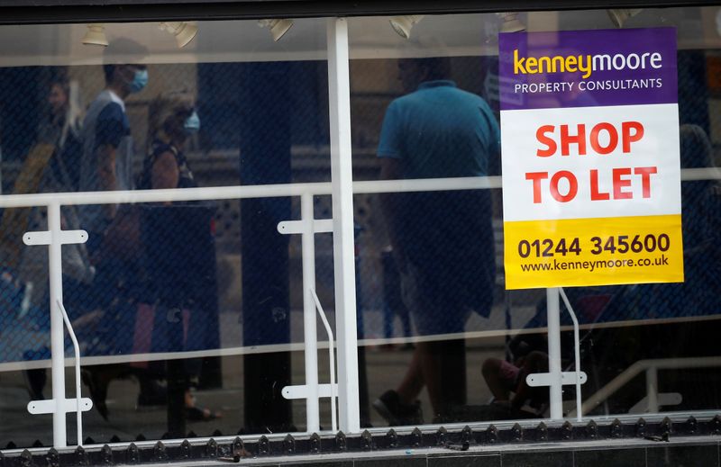 &copy; Reuters. FILE PHOTO: Shoppers are reflected in the window of a closed shop following the outbreak of the coronavirus disease (COVID-19) in Chester, Britain