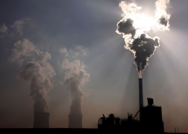 &copy; Reuters. FILE PHOTO: A coal-burning power plant can be seen behind a factory in the city of Baotou