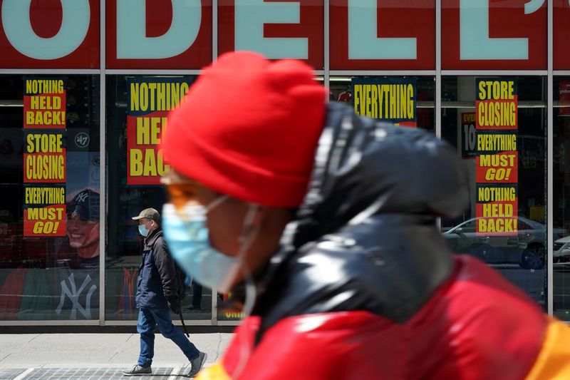 &copy; Reuters. FILE PHOTO: A man wearing a mask rides past a Modell&apos;s store that is closed, as retail sales suffer record drop during the outbreak of the coronavirus disease (COVID19) in New York