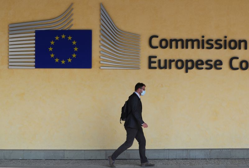 &copy; Reuters. Man wearing a protective mask walks past the EU Commission headquarters in Brussels