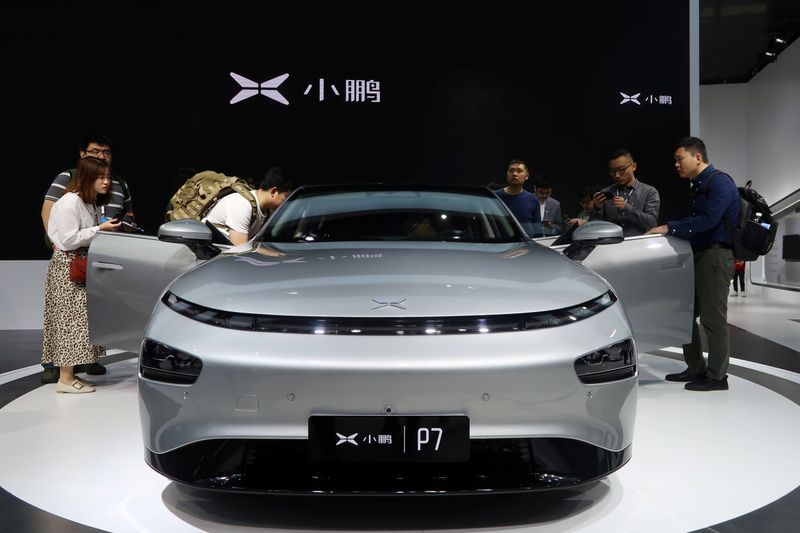 &copy; Reuters. FILE PHOTO: People look at XPeng&apos;s P7 sedan model displayed at the Guangzhou auto show in Guangzhou