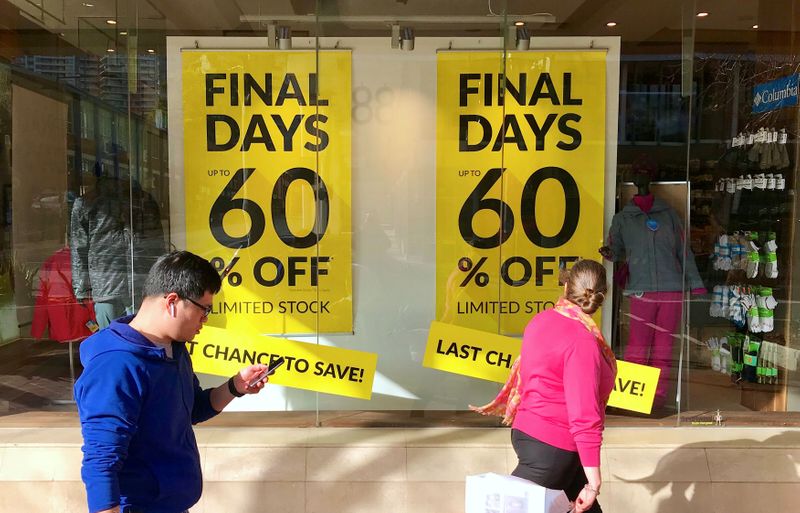 &copy; Reuters. Shoppers walk past sales signs on display in the window of a retail store at a shopping mall in Sydney