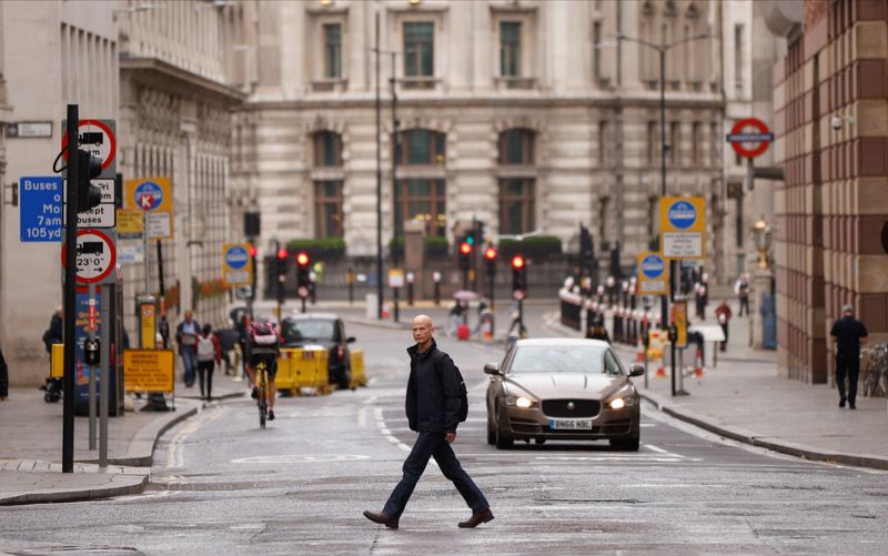 &copy; Reuters. A man crosses the road in the City of London financial district amid the outbreak of the coronavirus disease (COVID-19)