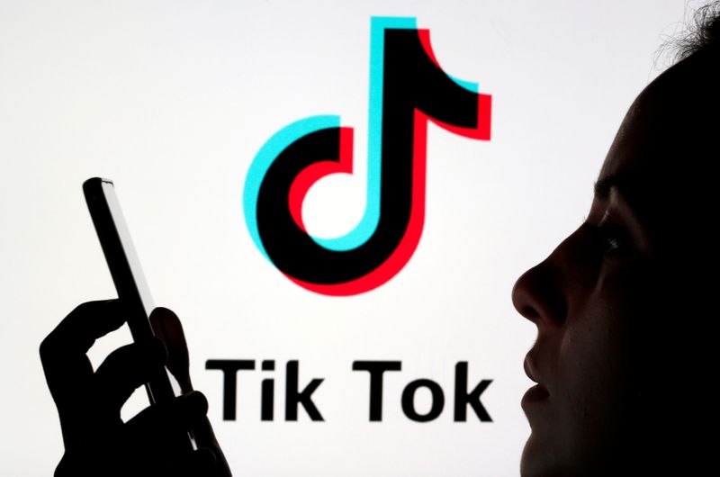 &copy; Reuters. FILE PHOTO: A person holds a smartphone as Tik Tok logo is displayed behind in this picture illustration