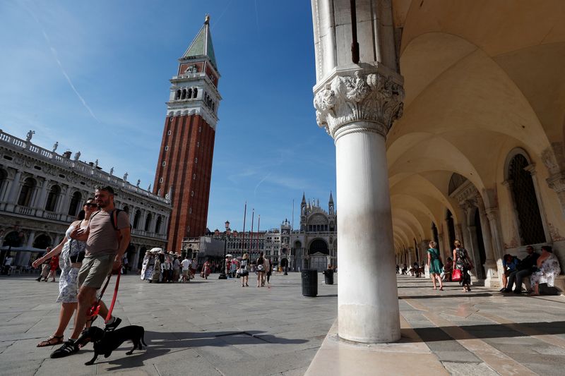 &copy; Reuters. Delle persone passeggiano in piazza San Marco