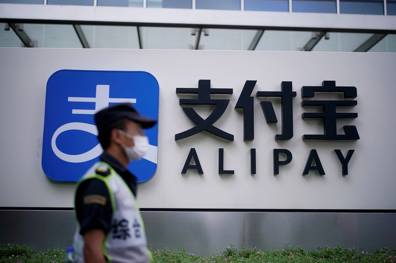 &copy; Reuters. FILE PHOTO: A security guard walks past an Alipay logo at the Shanghai office of Alipay, owned by Ant Group which is an affiliate of Chinese e-commerce giant Alibaba, in Shanghai