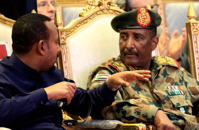 © Reuters. FILE PHOTO: Sudan's Head Of Transitional Military Council, Lieutenant General Abdel Fattah Al-Burhan, listens to Ethiopia's Prime Minister Abiy Ahmed during the signing of the power sharing deal, in Khartoum
