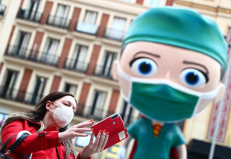 © Reuters. Una mujer haciéndose un selfie junto a una figura representando a un sanitario en Madrid, España, el 24 de septiembre de 2020