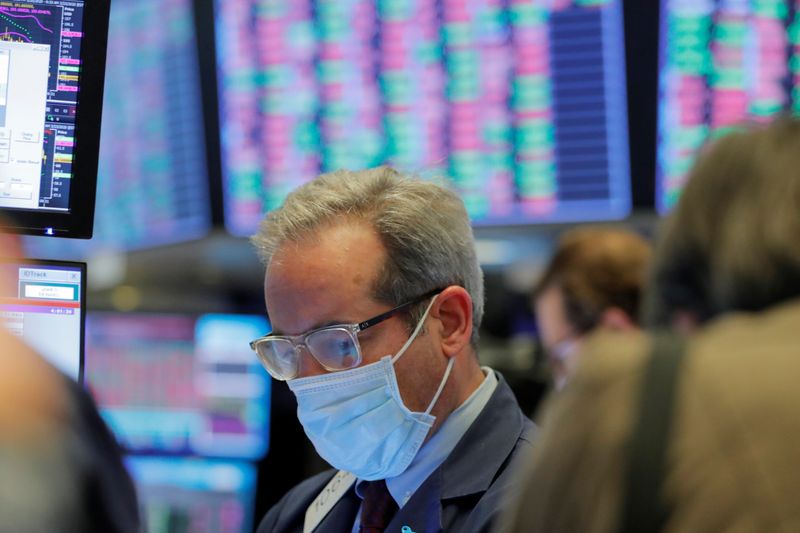&copy; Reuters. A trader wears a mask as he works on the floor of the New York Stock Exchange (NYSE) as the building prepares to close indefinitely due to the coronavirus disease (COVID-19) outbreak in New York