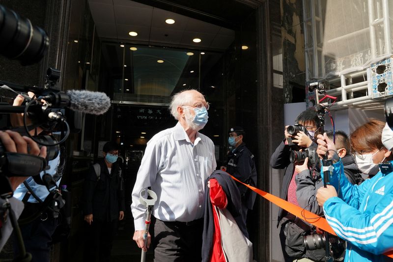 &copy; Reuters. American lawyer John Clancey walks out of a building as he is taken away by police officers in Hong Kong