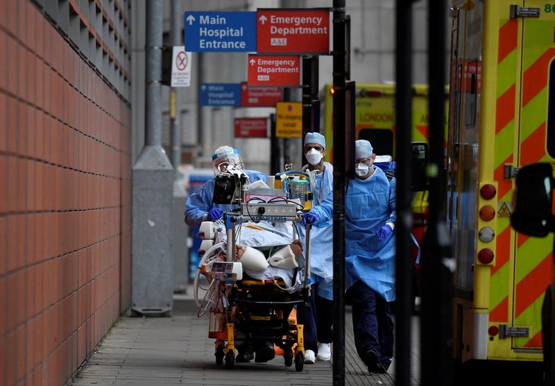 &copy; Reuters. Medical workers move a patient between ambulances outside of the Royal London Hospital amid the spread of the coronavirus disease (COVID-19) pandemic, London