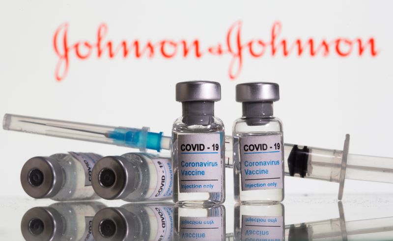 &copy; Reuters. Vials labelled &quot;COVID-19 Coronavirus Vaccine&quot; and sryinge are seen in front of displayed J&amp;J logo in this illustration