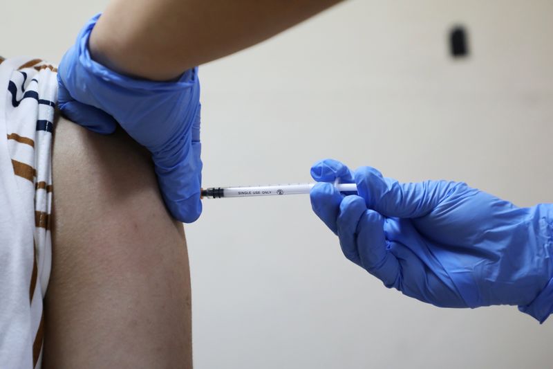 &copy; Reuters. Un operatore sanitario riceve un vaccino contro il Covid-19 presso il Kuala Lumpur Hospital