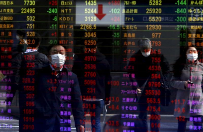 &copy; Reuters. Pedestrians are reflected in an electronic board displaying various stock prices at a brokerage in Tokyo