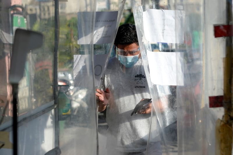 &copy; Reuters. FOTO DE ARCHIVO: Un hombre con mascarilla y escudo facial en Pásay