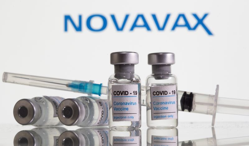 &copy; Reuters. Vials labelled &quot;COVID-19 Coronavirus Vaccine&quot; and sryinge are seen in front of displayed Novavax logo in this illustration