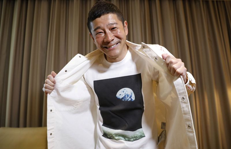 © Reuters. Japanese billionaire Yusaku Maezawa poses with his T-shirt bearing an image of Earth during an interview with Reuters in Tokyo