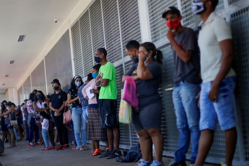 &copy; Reuters. Pessoas aguardam em fila em frente de agência da Caixa para tentar receber pagamento do auxílio emergencial, Ceilândia-DF