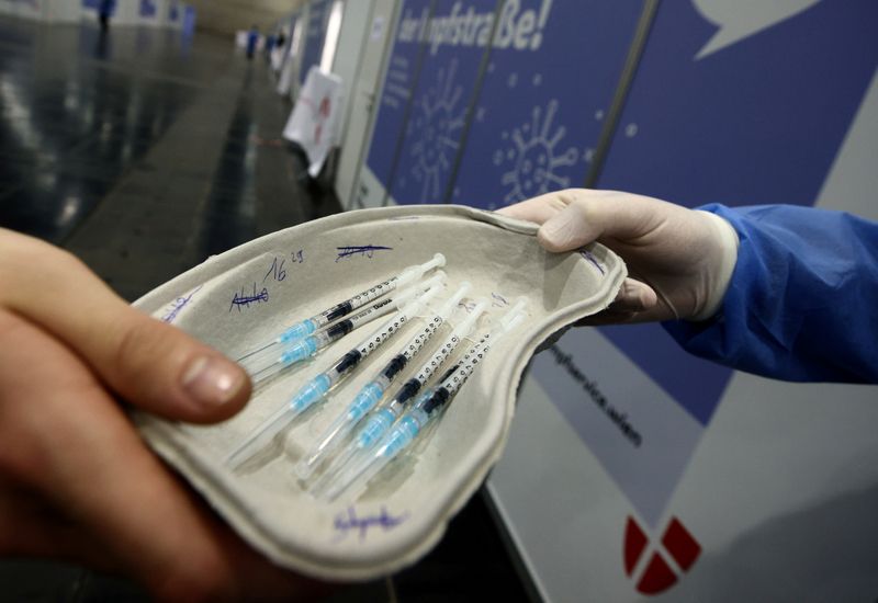 &copy; Reuters. Un trabajador sanitario entrega dosis de la vacuna COVID-19 de Pfizer-BioNTech a un médico en el Centro de Congresos Messe Wien, habilitado como centro de vacunación contra la enfermedad del coronavirus, en Viena