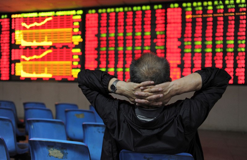 &copy; Reuters. Imagen de archivo de un inversor con sus manos en la nuca frente a una pantalla electrónica que muestra información bursátil en una correduría en Hefei