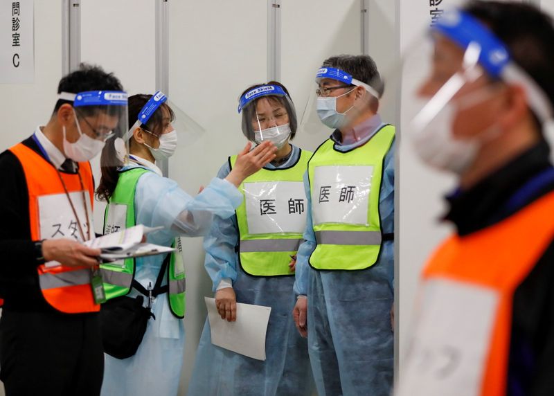 &copy; Reuters. Trabajadores médicos usan mascarillas y escudos faciales mientras participan en una simulación de vacunación en el marco de los preparativos del municipio local para una campaña de inoculación masiva, en un centro comercial en Sakura, al este de Toki