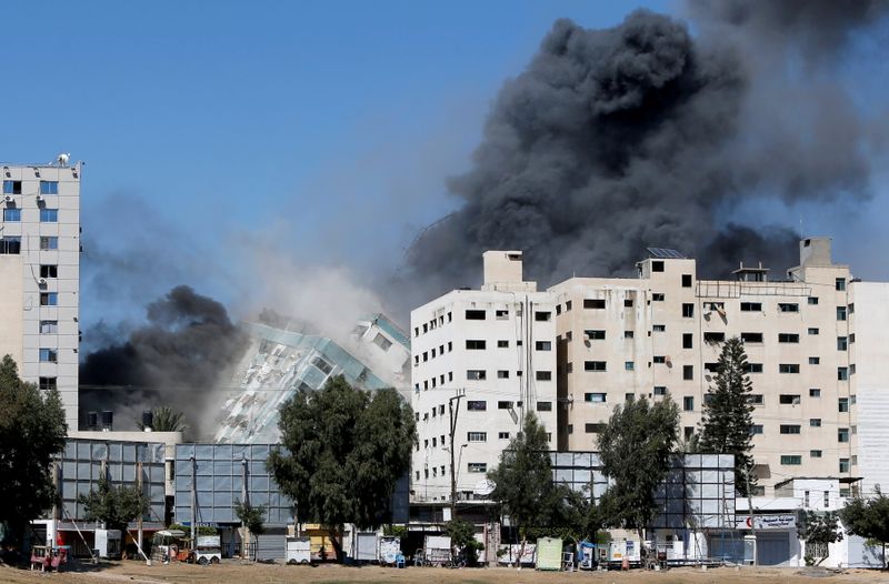 © Reuters. مبنى يضم مكتبي وكالة أسوشيتد برس وقناة الجزيرة لدى انهياره جراء ضربة إسرائيلية في غزة يوم السبت. تصوير: محمد سالم - رويترز