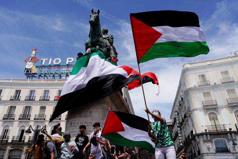 &copy; Reuters. أشخاص يحملون العلم الفلسطيني دعما للفلسطينيين في مدريد يوم السبت. تصوير: خوان مدينا - رويترز