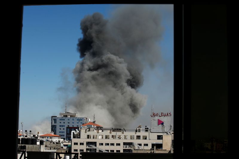 &copy; Reuters. الدخان يتصاعد فوق برج يضم مكاتب لمؤسسات إعلامية في مدينة غزة يوم السبت. تصوير: صهيب سالم - رويترز. 