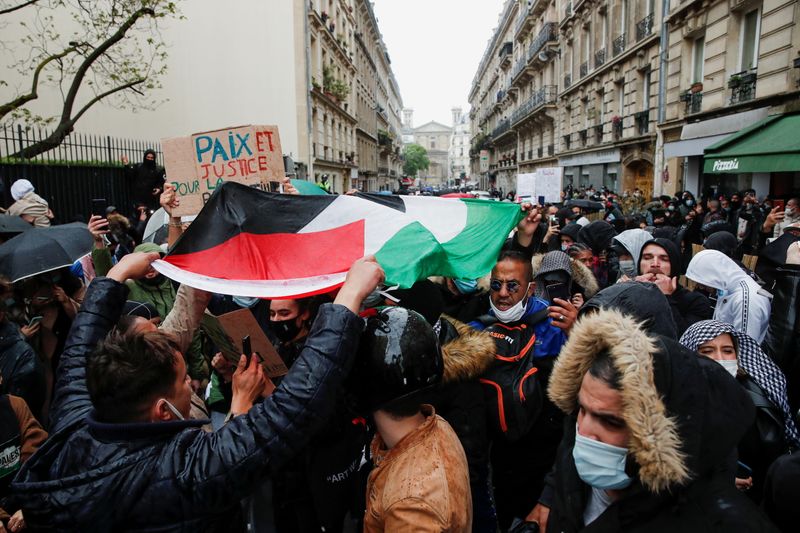 &copy; Reuters. متظاهرون يرفعون علم فلسطيني في احتجاج ضد الهجمات الإسرائيلية على غزة في العاصمة الفرنسية باريس يوم السبت. تصوير: بنوا تيسيه - رويترز. 
